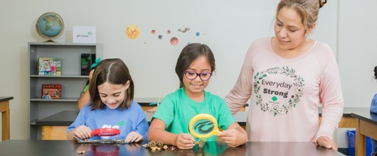 Girls with microscope for Volunteer Essentials