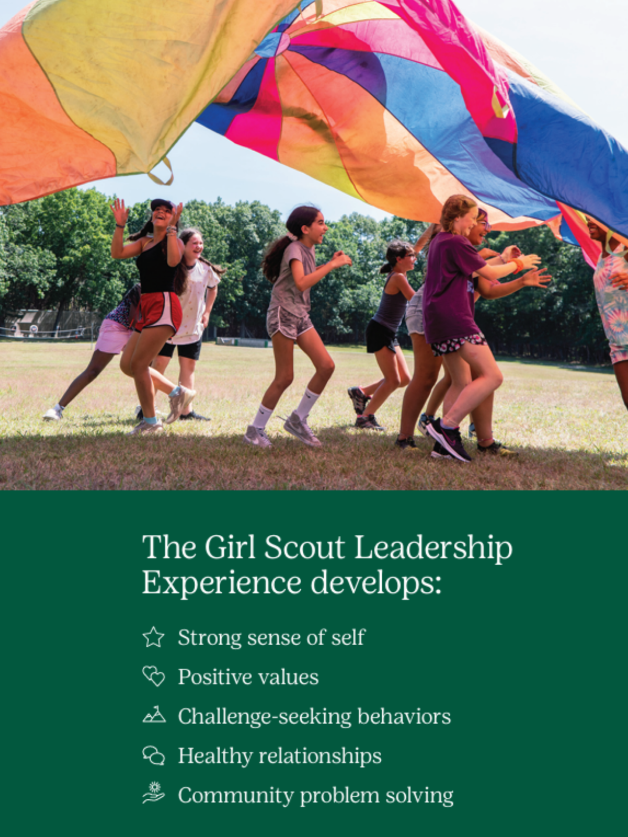 image with Girl Scouts outside playing with a large colorful parachute. The text below the image says, "The Girl Scout Leadership Experience develops a strong sense of self, positive values, challenge-seeking behaviors, healthy relationships, and community problem solving."